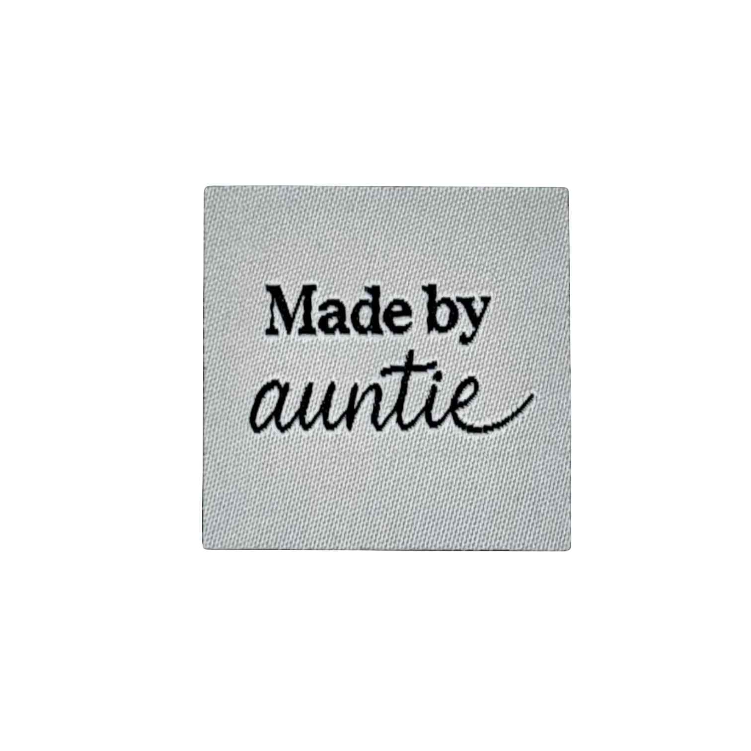 Textiellabel met de tekst 'Made by auntie' geborduurd in zwart op grijs weefsel