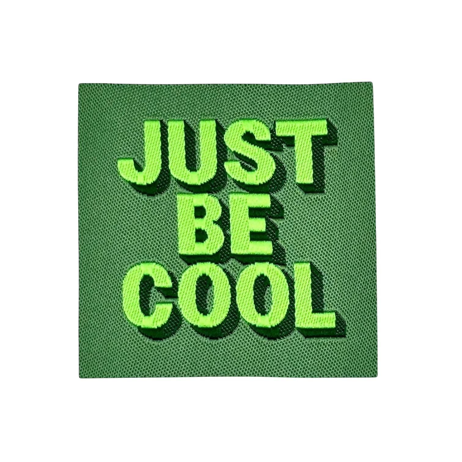 Geborduurd tekstbord met neongele letters 'JUST BE COOL' op donkergroene stoffen achtergrond